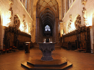 Obraz premium Interior view of Saint-Martin gothic cathedral nave featuring ribbed vaulting, wooden choir stalls, and ornate font. Colmar, Alsace, France