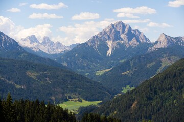 Fototapeta premium Majestic scenery of rough mountain ridge near grassy hills 