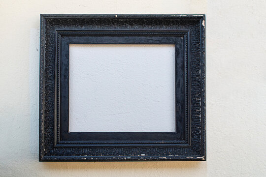 old black frame hanging on a wall