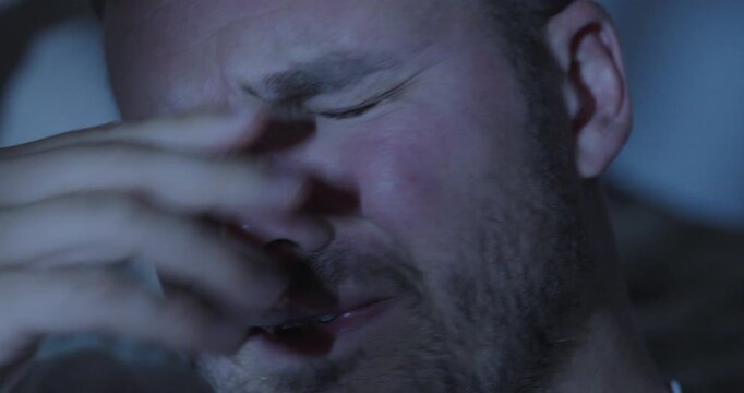 Close up of a man crying in dim light at night