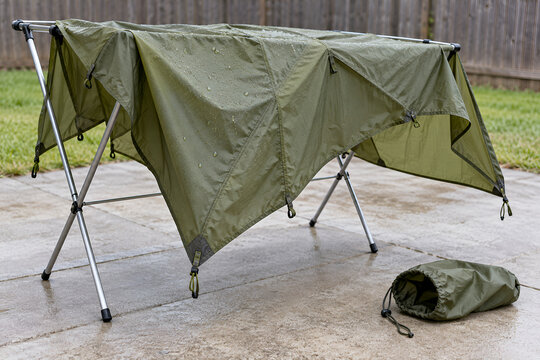 Tent rainfly airing on a rack beside an empty storage sack