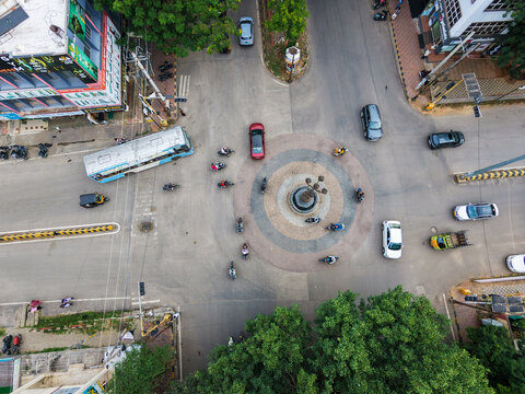 Drone shot of a busy traffic circle, aerial view shows automobiles navigating the bustling urban roundabout during Dussehra festival in Mysuru, India.