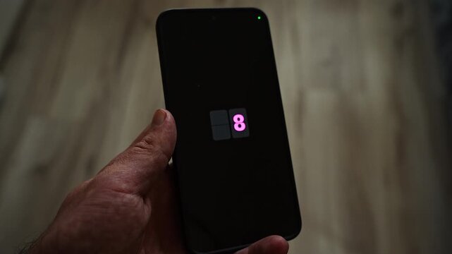 A countdown from 10 to 0 flips through pink digits on a smartphone held in one hand, then Welcome 2027 appears on the screen. A New Year Eve midnight countdown for party openers, celebrations and the
