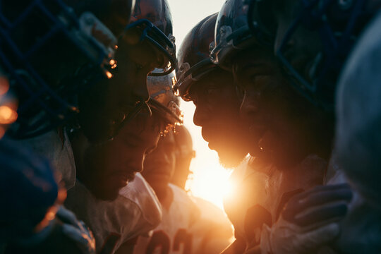 American Football Team Huddling Together at Sunset