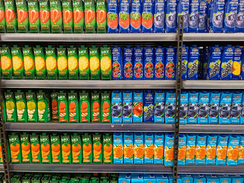Assorted fruit juice cartons in supermarket. Shelf stocked with an assortment of fruit juice cartons in various flavors including orange, lemon, apple, and berry.