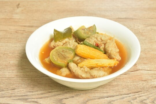 spicy boiled clown featherback fish ball with mixed vegetable in jungle curry soup Thai food in bowl
