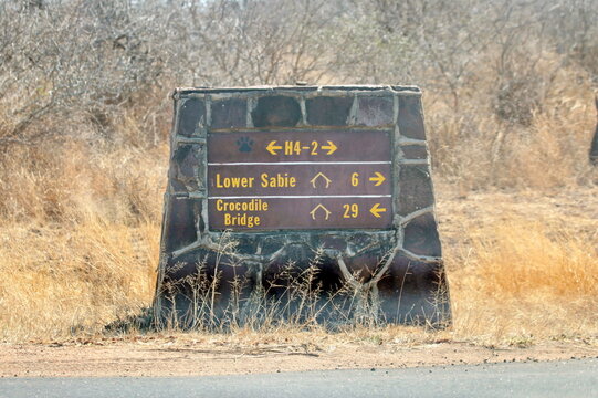 Stone road sign showing iconic road H4-2 between two iconic camps, Skukuza and Lower Sabie, in Kruger National Park, South Africa