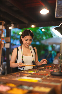 Asian woman making handmade bead necklace at Khlong Bang Luang workshop Bangkok Thailand local culture tourism