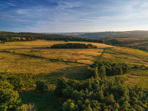 Beautiful drone landscape image view over Burbage South Edge in Peak District during Summer heather sunset