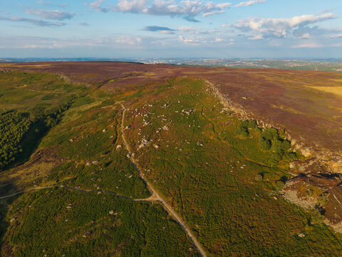 Beautiful drone landscape image view over Burbage South Edge in Peak District during Summer heather sunset