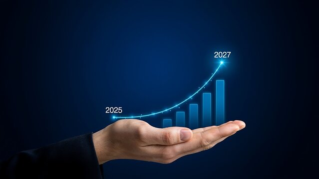 A human hand holds a glowing blue upward trending bar graph with years 2025 and 2027 indicated against a dark blue background