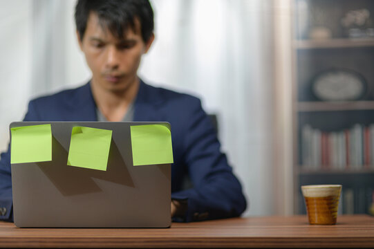 Young Man Working on Laptop with Sticky Notes in a Comfortable Home Office