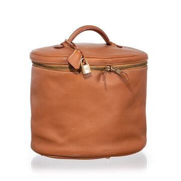 Brown leather cylindrical beauty case with gold hardware, lock, and clasp. Photographed against a white background.