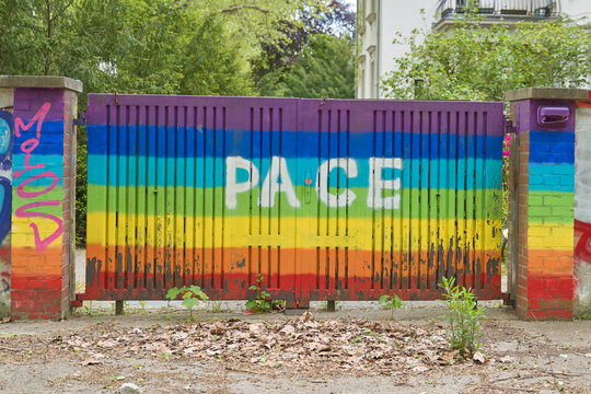 Pace, das italienische Wort f&uuml;r Frieden und die Pac-Fahne oder Regenbogen-Fahne an einer Toreinfahrt 