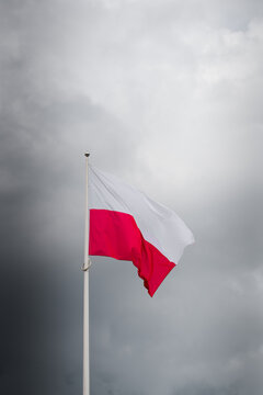 Die polnische Nationalflagge vor einem dramatischen bew&ouml;lkten Himmel