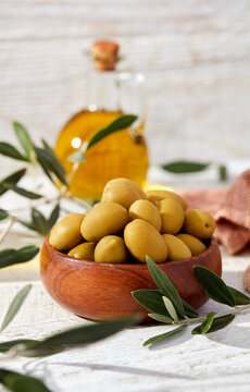 Wooden bowl of olives with olive oil