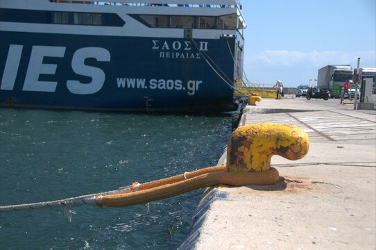 Ferry docked beside a yellow mooring bollard