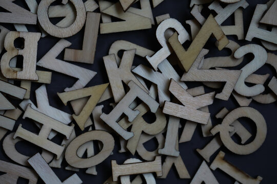 Abstract Overlay of Wooden Alphabet Letters and Numbers on Dark Background
