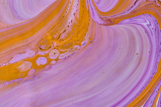 Abstract fluid art texture with swirling purple, pink, and vibrant yellow acrylic paint bubbles.