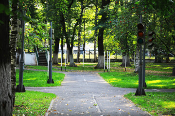 Fototapeta premium Peaceful Urban Park Intersection with Traffic Lights and Lush Greenery