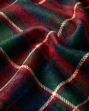 An extreme macro shot of finely woven traditional tartan wool fabric.