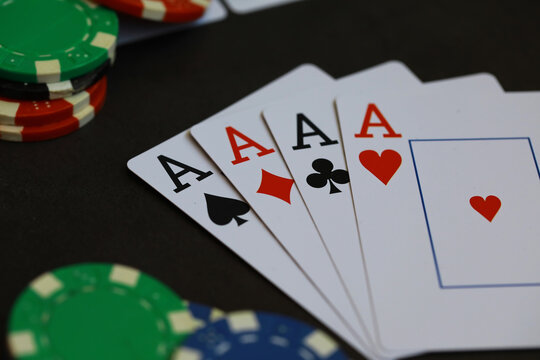 Winning Poker Hand with Four Aces and Colorful Poker Chips in Dramatic Casino Setting
