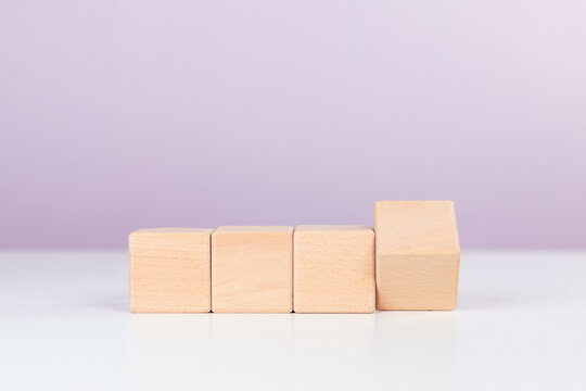 Four wooden blocks in horizontal row with one flipping cube for change concept