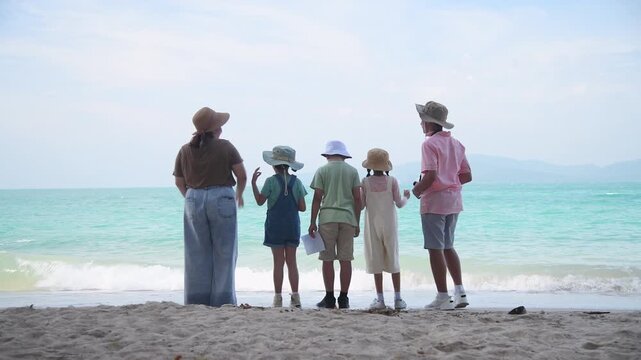 Group of teacher and school children on ecotourist trip  learning show beach take care of environment.