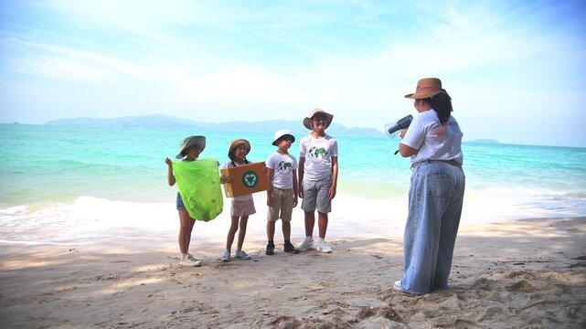 Group of teacher and school children on ecotourist trip  learning show beach take care of environment.