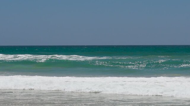 green waves breaking on the beach