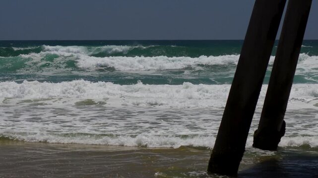 Large surf breaking on the pier in slow motion