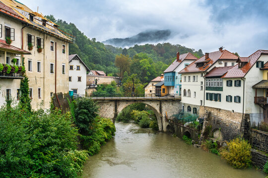 Scenic view of Skofja Loka old town with stone bridge over river in Slovenia