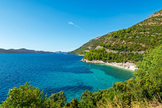 Scenic view of a beautiful turquoise beach with green hills and clear blue sea in Croatia