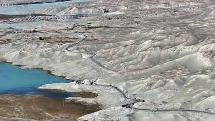 Fototapeta premium winding road along white sand lake in xinjiang desert landscape