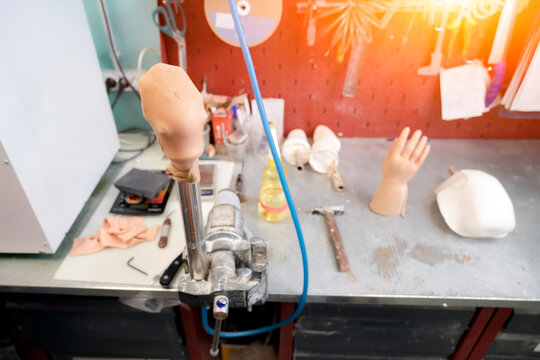 Unfinished prosthetic socket resting on a workbench in a rehabilitation technology workshop.