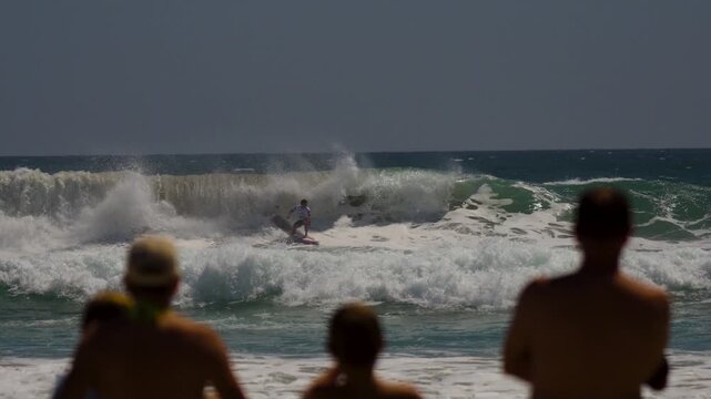surfer in white pumping down a large wave