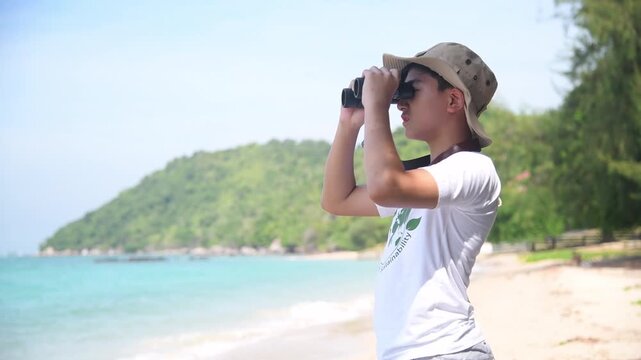 Children with binoculars holds hands and looks into distance and something joyfully screams they are wearing save world t-shirt with forest nature summer travel holiday concept.