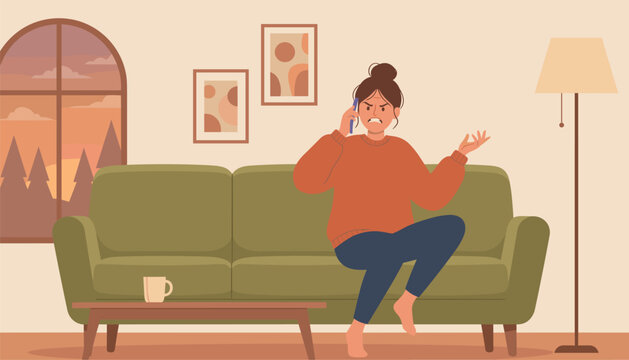 Frustrated woman sitting on a green living room sofa looking angry while talking on her mobile phone.