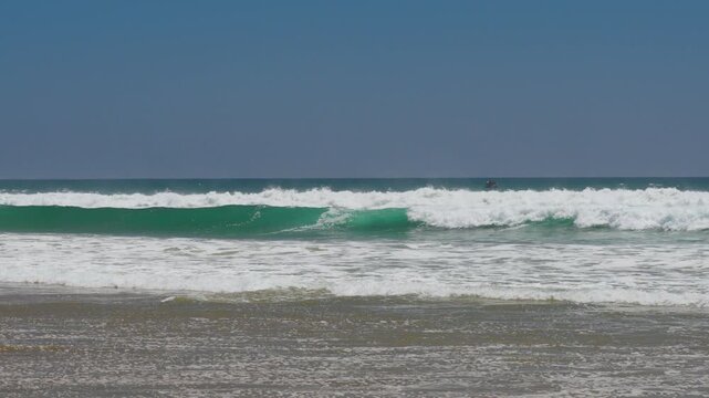 Wide shot of slow motion waves breaking in orange county