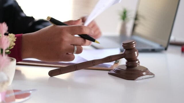 A judge examines documents in court, flipping through case filing records before determining the verdict. The concept of a judge's work.