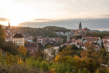 Scenic elevated view of Cesky Krumlov with its castle and river surrounded by colorful autumn trees in sunset light. © jiriviehmann