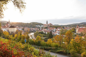 Scenic elevated view of Cesky Krumlov with its castle and river surrounded by colorful autumn trees in sunset light. © jiriviehmann