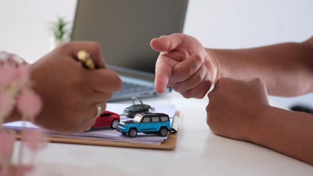 A discussion between a car buyer and a dealer regarding the selection of a desired vehicle. The dealer explains the advantages and disadvantages of each unit.
