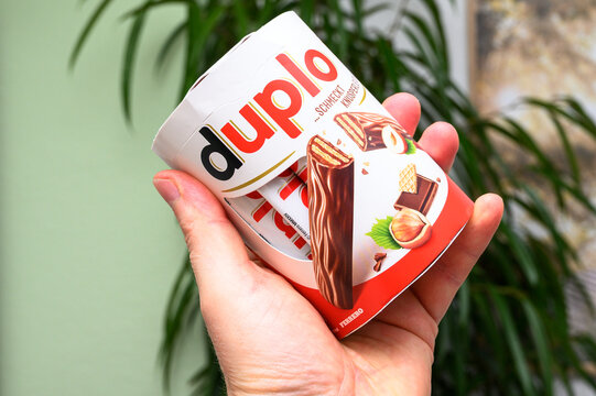 Iserlohn, Germany - October 07, 2026: A person holds a cardboard package of Ferrero Duplo chocolate bars in hand indoors