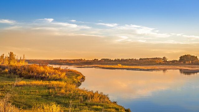 Golden Autumn Sunset Reflected on a Serene Prairie River