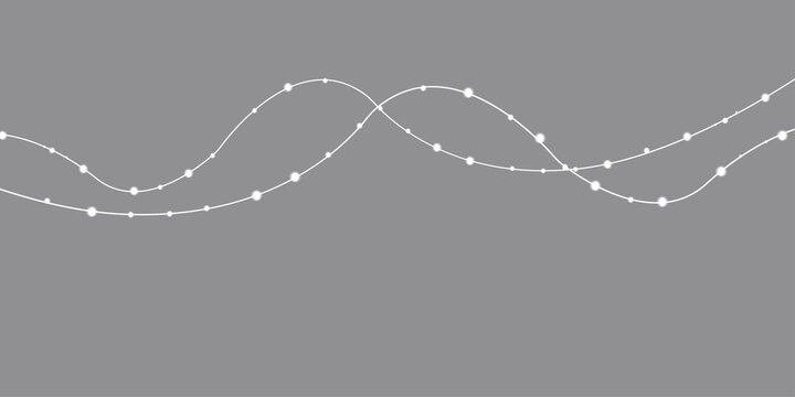 Decorative white string lights with glowing bulbs on grey background