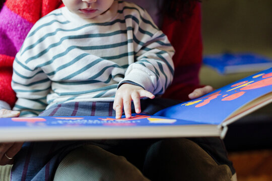 Toddler Reading Picture Book With Parent