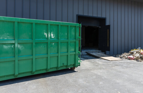 Large Green Industrial Waste Dumpster Container at Construction Site