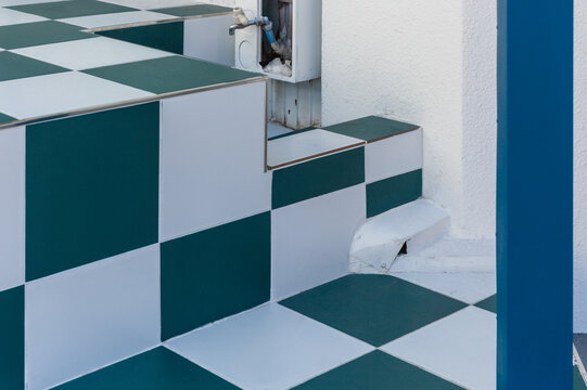 Green and white checkered tiled outdoor stairs with a blue pillar.