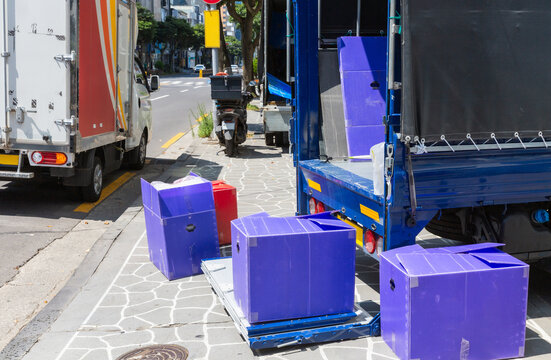 Close-Up View of Purple Moving Boxes on Delivery Truck Liftgate